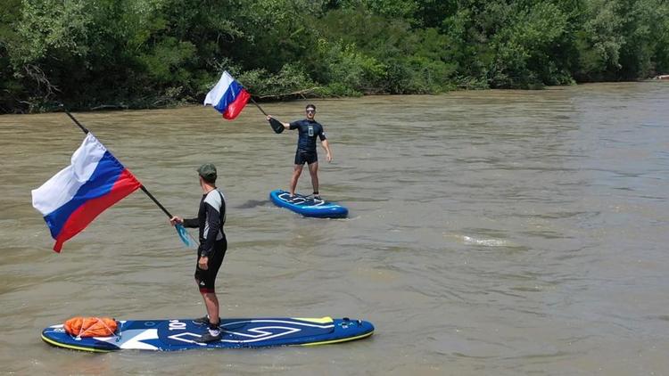 В Невинномысске сапсёрфингисты развернули флаги России во время сплава по реке Кубань